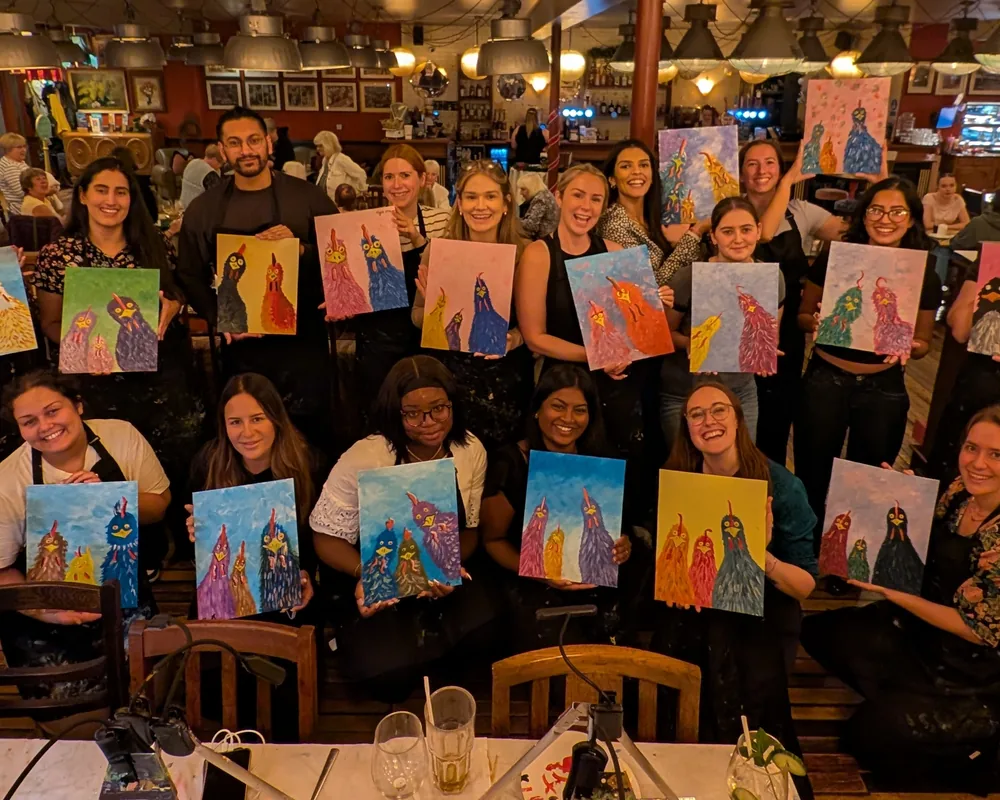 The Innovative Trials team at a painting night, each holding up their canvas
