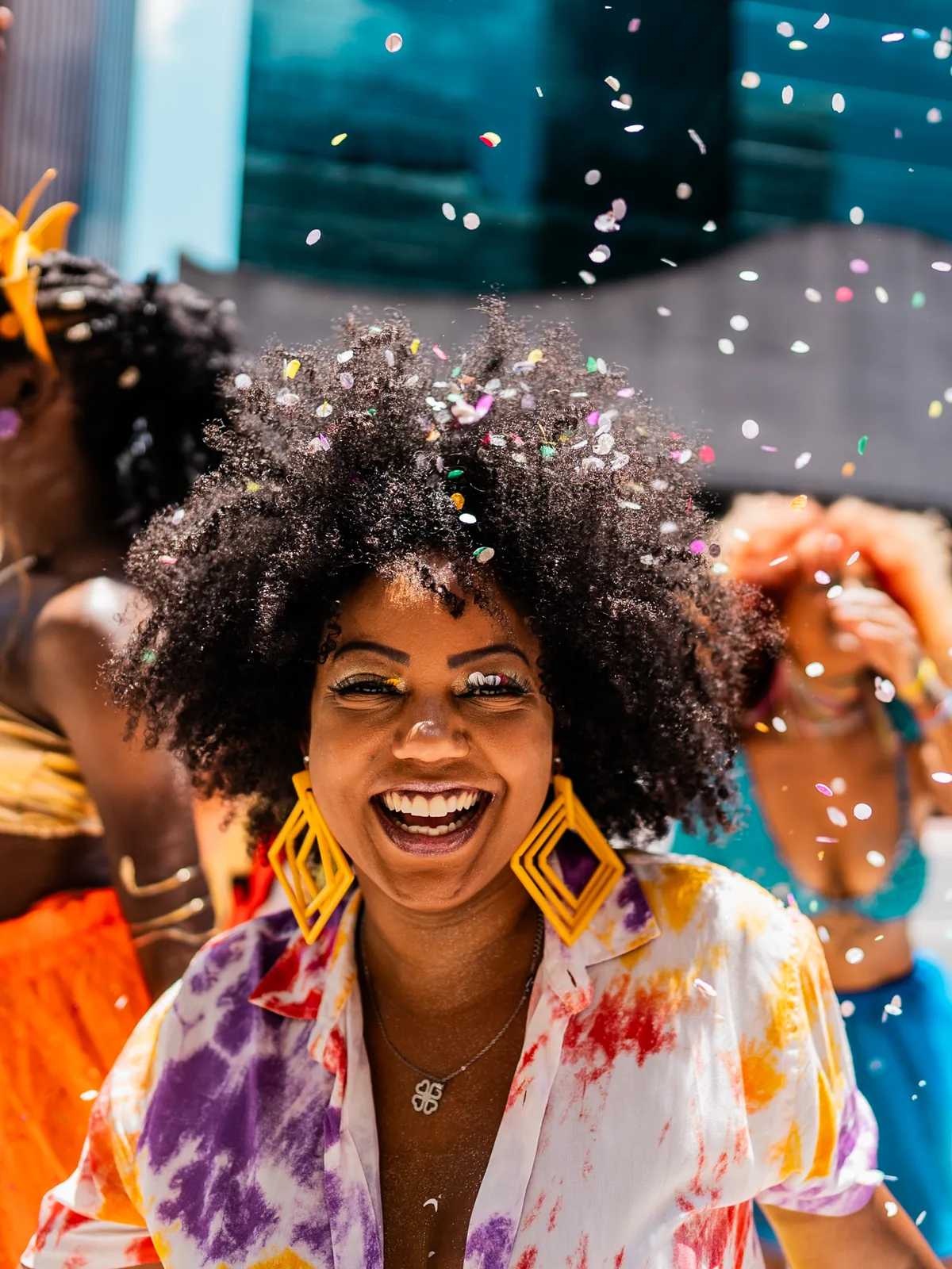 A woman laughing in the middle of a street carnival